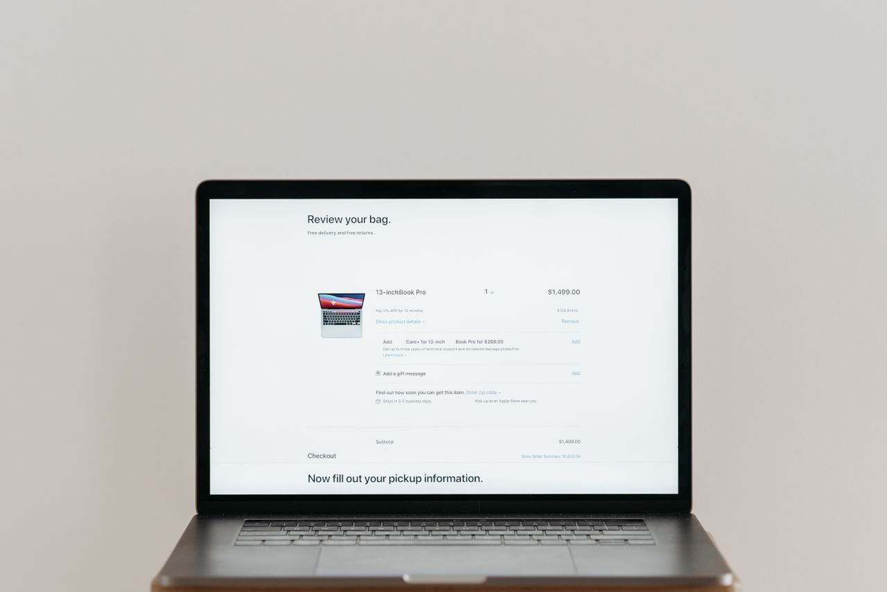 Minimalist laptop showing an online checkout screen on a white background, ideal for tech context.